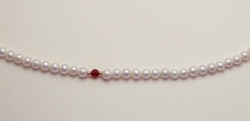 Close view of the actual red crystal accent and nearby freshwater pearls